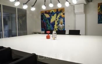 Modern conference room at Kanaalweg 33 office space rental, Capelle aan den IJssel, featuring a large white table and vibrant artwork.