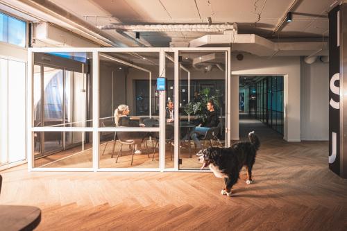 Modern office space at Rietbaan 2-12, Capelle aan den IJssel with a glass-walled meeting room, featuring a wooden floor. Perfect for office space rental.