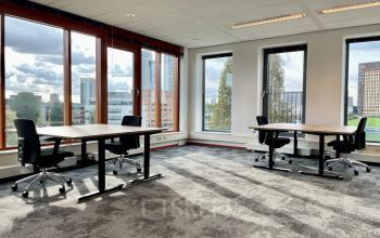 Bright and airy office interior at Fascinatio Boulevard 562 in Capelle aan den IJssel, featuring large windows, two modern desks with chairs, available for office space rental.