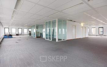 Spacious office interior at Fascinatio Boulevard 562, Capelle aan den IJssel featuring open floorplan and glass-enclosed conference rooms, ideal for office space rental.
