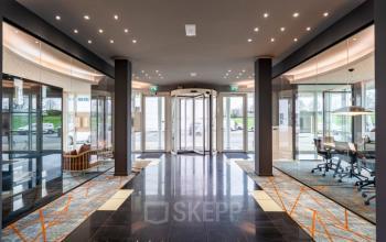 Spacious entrance of Rhijnspoor 209-263 in Capelle aan den IJssel, featuring elegant glass doors and modern decor, ideal for office space rental.