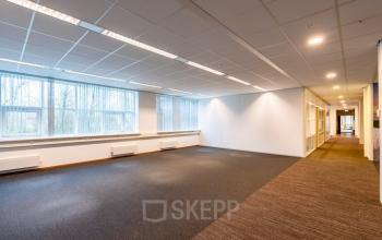 Open office space with large windows, carpet flooring, and overhead lighting in Rhijnspoor 209-263, Capelle aan den IJssel, ideal for office space rental.