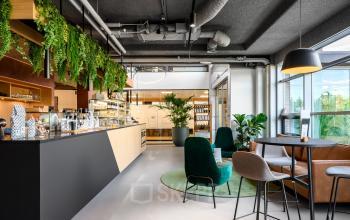 Modern office space rental at Fascinatio Boulevard 522, Capelle aan den IJssel, with stylish lounge area featuring elegant furniture, greenery, and abundant natural light.