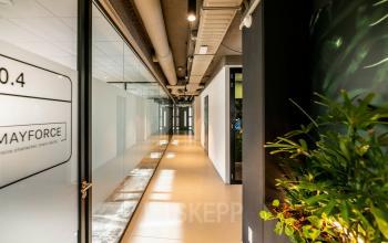 Bright and modern corridor at Fascinatio Boulevard 522, Capelle aan den IJssel, ideal for office space rental. The hallway features sleek glass walls and industrial-style ceilings.