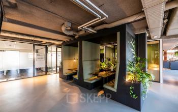 Modern office space at Fascinatio Boulevard 522, Capelle aan den IJssel, featuring a stylish open floor plan with vibrant greenery and cozy work booths, ideal for office space rental.