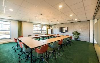 Spacious conference room at Fascinatio Boulevard 522, featuring a large meeting table, modern chairs, and ample natural light. Ideal for office space rental in Capelle aan den IJssel.