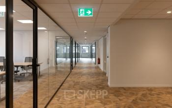 Corridor in an office space at Essebaan 63, Capelle aan den IJssel, featuring glass partitions and modern flooring, ideal for office space rental.