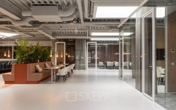 Open office space rental at Essebaan 63, Capelle aan den IJssel, featuring modern furniture and glass partitions for collaborative work.
