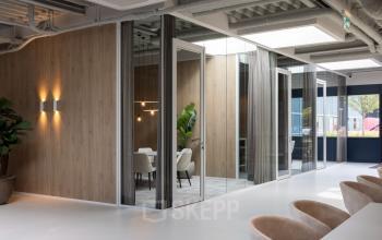 Modern office space at Essebaan 63, Capelle aan den IJssel, featuring glass partitions, sleek lighting, and contemporary furniture. Perfect for a professional environment and office space rental opportunities.