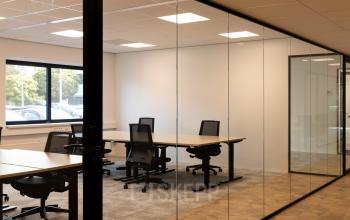 Glass-walled office space at Essebaan 63, Capelle aan den IJssel, featuring desks and chairs, ideal for office space rental.