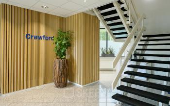 Modern office entrance at Vlierbaan 20, Capelle aan den IJssel, with a staircase and decorative plants, available for office space rental.