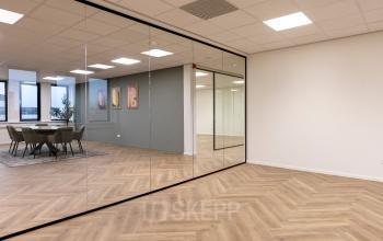 Modern office to rent at Vlierbaan 20, Capelle aan den IJssel, featuring glass walls and wooden flooring, ideal for office space rental.