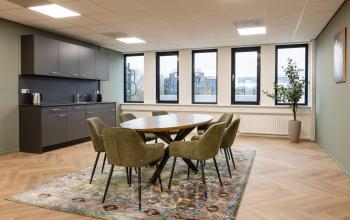 Spacious furnished office at Vlierbaan 20, Capelle aan den IJssel, featuring a round table with chairs and modern amenities for office space rental.