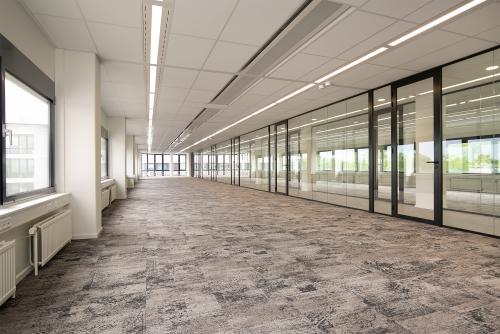 Spacious unfurnished office interior at Rijnzathe 6, De Meern, available for office space rental, featuring large windows and glass partitions for natural light.