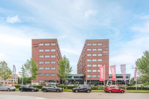 Exterior view of Rijnzathe 12 in De Meern featuring a modern office complex with multiple parked cars in the foreground.