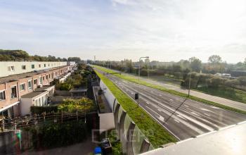 Exterior view of Marshalllaan 2 in Delft showing a peaceful roadside environment, ideal for those seeking office space rental with ease of access.