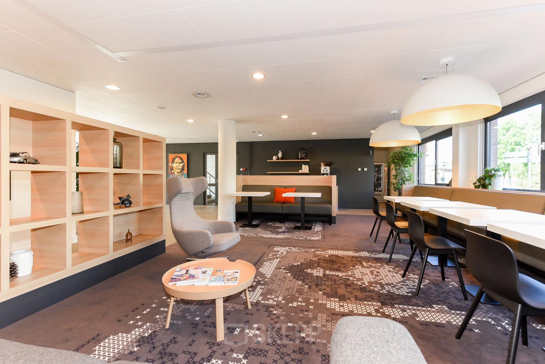 Bright, furnished office space with modern seating and large windows at Marshalllaan 2, Delft. Ideal for office space rental with flexible work areas.