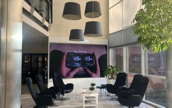 Modern lobby area with cozy black chairs, a small table, and large windows, perfect for office space rental at Olof Palmestraat 10, Delft.
