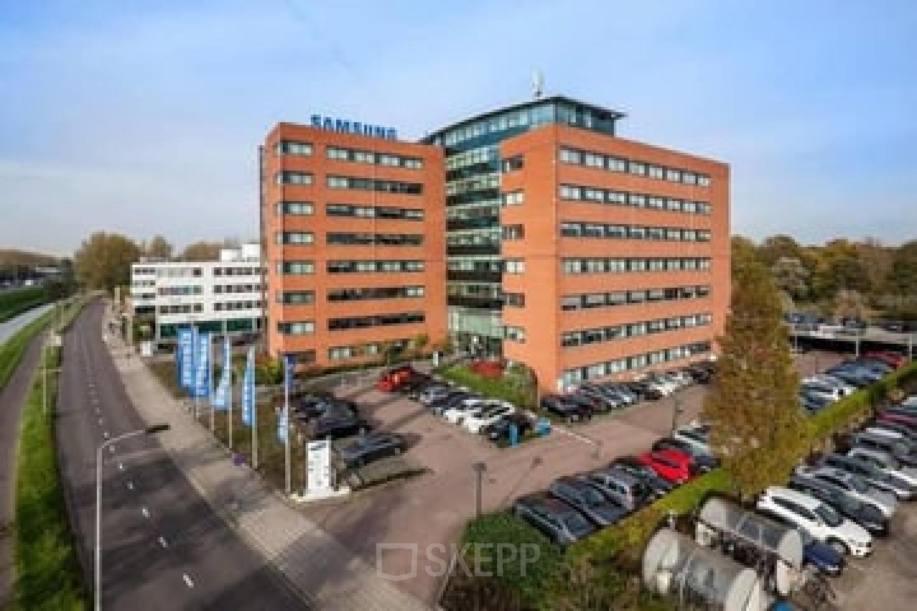 Exterior view of the office building at Olof Palmerstraat 10, Delft, showcasing a modern design, ample parking, and an inviting entrance, ideal for professionals seeking office space rental.