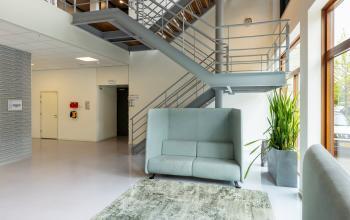 Modern office space rental at Delftechpark 9 in Delft, featuring sleek staircase and comfortable seating, ideal for businesses looking to rent office space.