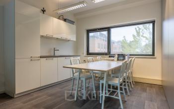 Bright office space with a meeting area and kitchen setup at Delftechpark 9, perfect for your office space rental needs in Delft.