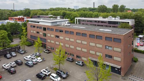 Exterior view of an office building at Delftechpark 9, Delft with an adjacent parking area, ideal for office space rental.