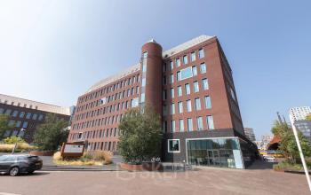 Exterior view of an office building at Willemsplein 2, Den Bosch, ideal for office space rental with a modern facade and ample parking.