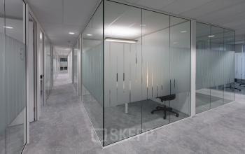 Modern, glass-walled offices at Willemsplein 2, Den Bosch, featuring individual workspaces and grey carpets. Ideal office space rental for professionals.