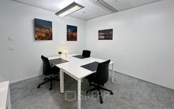 Modern office space for rent at Willemsplein 2, Den Bosch, featuring elegant workstations with black chairs, stylish decor, and minimalistic design.