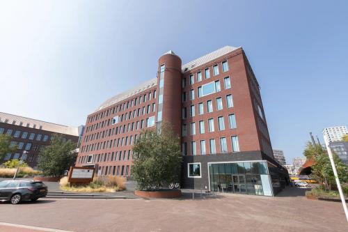 Exterior view of an office building at Willemsplein 2, Den Bosch, ideal for office space rental with a modern facade and ample parking.