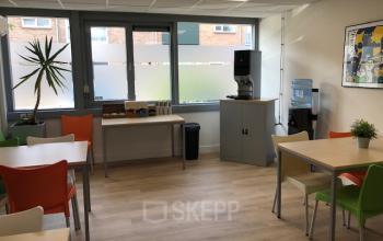 Office at Eemweg 1-9 in Den Bosch featuring a furnished lounge area with tables, colorful chairs, a coffee machine, and a water dispenser, suitable for office space rental.
