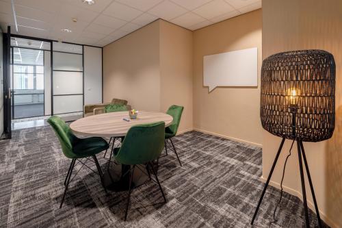 Modern workspace at Europalaan 4, Den Bosch featuring round table with chairs, carpet flooring, and stylish lighting, ideal for office space rental.