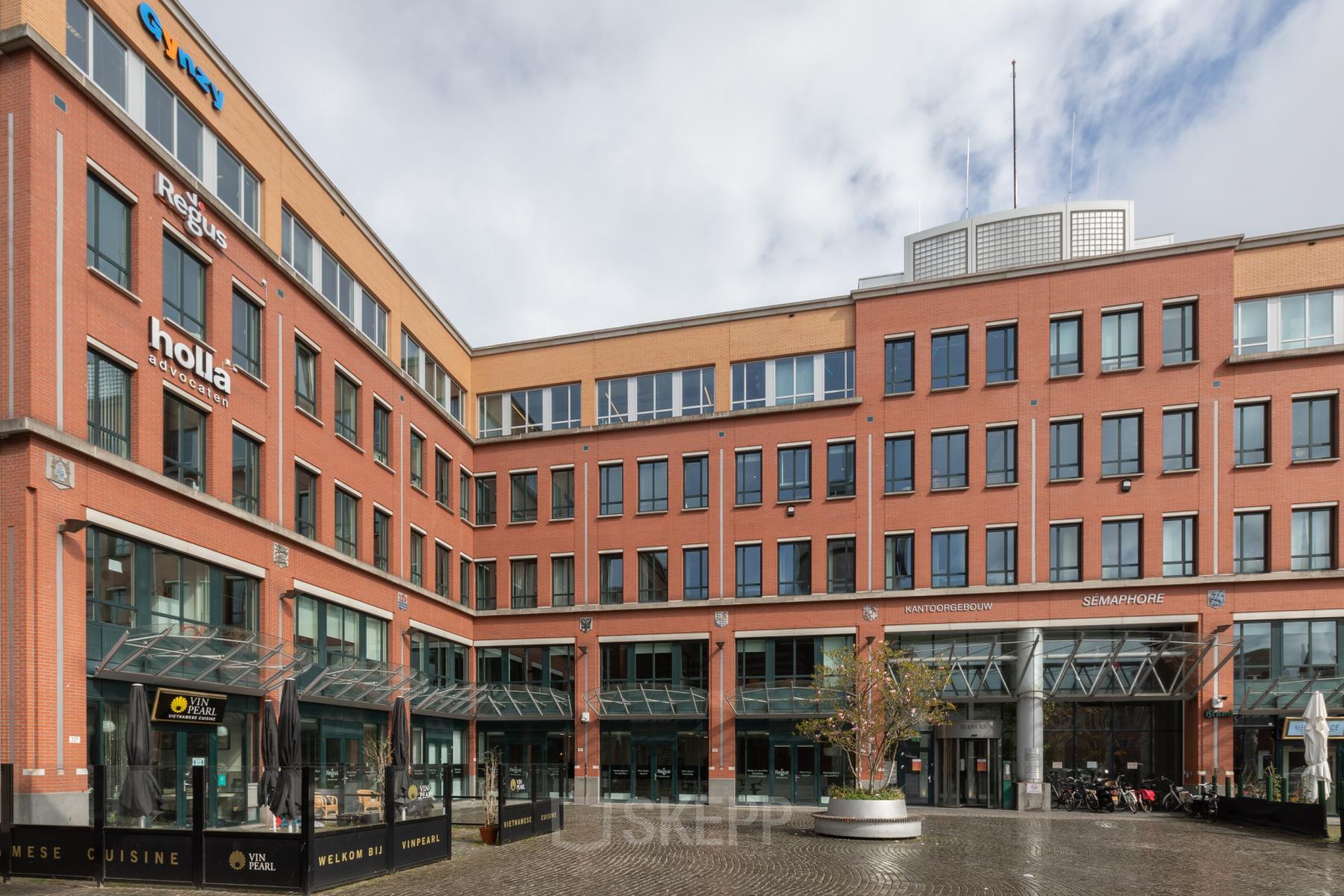 Modern office space rental at Stationsplein 91 in Den Bosch, showcasing a well-maintained exterior with commercial ground floor.