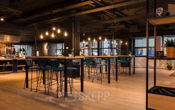 Modern furnished office space at Bruistensingel 400, Den Bosch featuring high tables and ample lighting, ideal for effective work and collaboration.