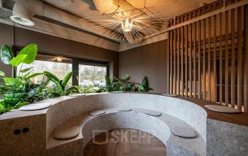 Modern office lounge at Pettelaarpark 110, Den Bosch with stylish seating and lush greenery, ideal for relaxation or informal meetings. Consider this dynamic office space rental for a vibrant work environment.