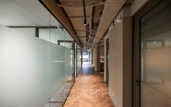Interior hallway at Pettelaarpark 110, Den Bosch, featuring a modern glass and wood design, suitable for office space rental.
