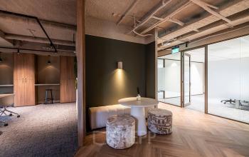Modern office space at Pettelaarpark 110, Den Bosch, featuring stylish furnishings including a small table with stools and subtle lighting, ideal for office space rental.