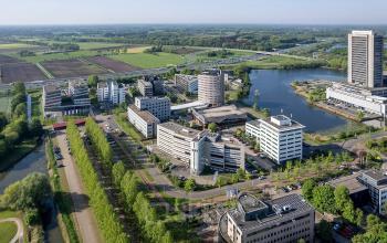 An aerial view of Pettelaarpark 110 showcasing modern office buildings surrounded by lush greenery and water features in Den Bosch, highlighting an attractive location for office space rental.