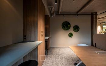 Modern office space rental at Pettelaarpark 110, Den Bosch featuring stylish wooden furnishings and innovative design elements including moss wall art, creating an inviting work environment.