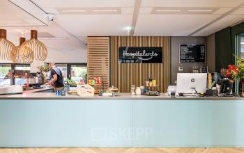Modern lounge area at Pettelaarpark 110 in Den Bosch featuring a sleek counter with pendant lighting, ideal for office space rental.