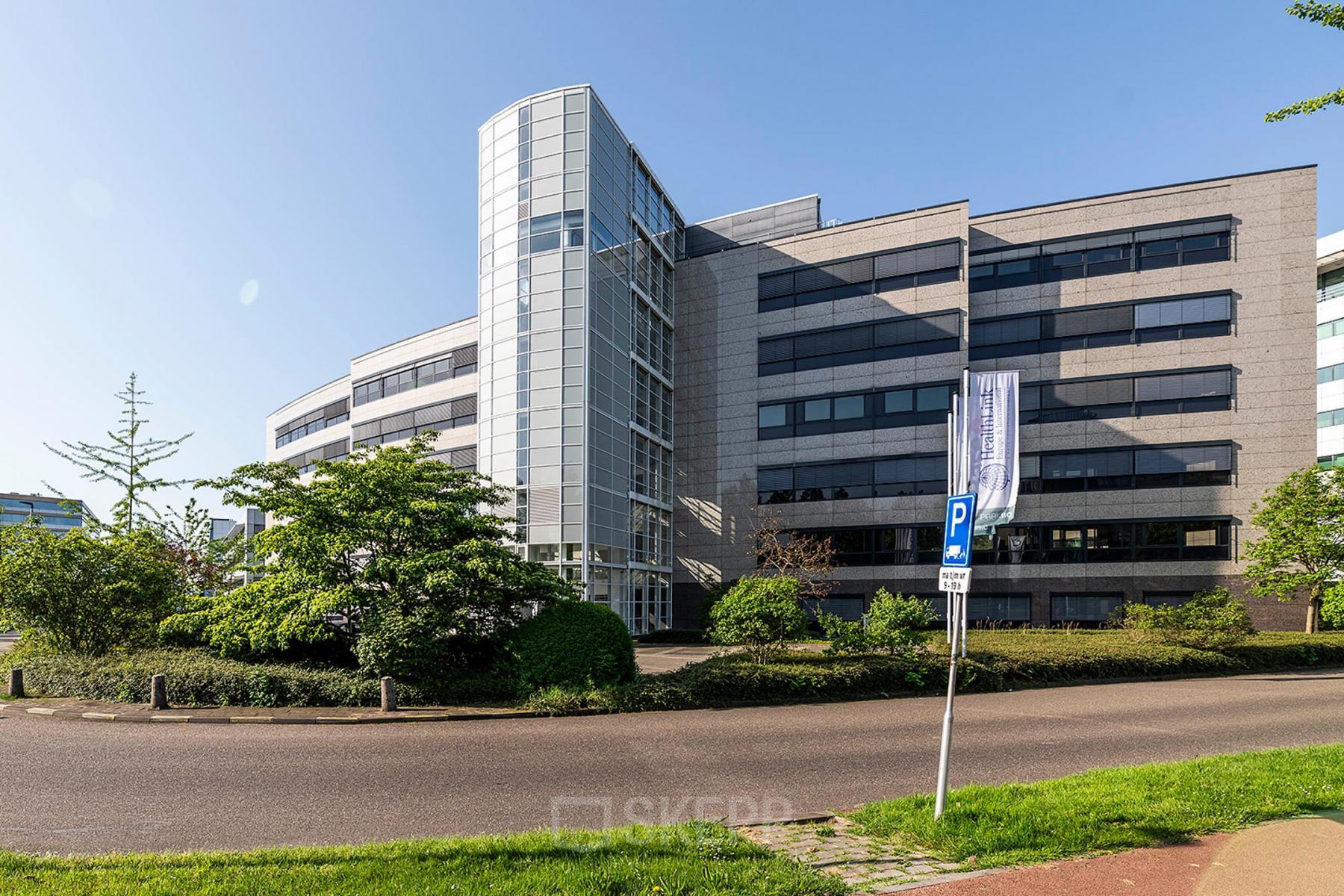 Exterior of modern office building at Pettelaarpark 110, Den Bosch, with glass facade and surrounding greenery, suitable for office space rental.