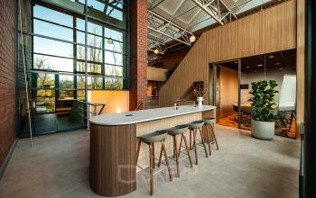 Interior view of a modern office to rent at Hambakenwetering 5, Den Bosch, showcasing a stylish furnished lounge and workspaces with natural light.