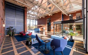 Spacious office space rental at Hambakenwetering 5, Den Bosch, featuring bright interiors with modern furnishings, large windows, and comfortable seating areas. Ideal for collaborative work and meetings.