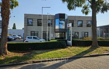Exterior view of the office building at Hambakenwetering 18, Den Bosch, featuring a modern facade with ample parking. Ideal for office space rental.