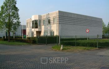 Modern two-story office building at Hambakenwetering 18, Den Bosch, featuring a flat roof and large windows. Ideal for businesses looking for office space rental with ample parking in a quiet, professional area.