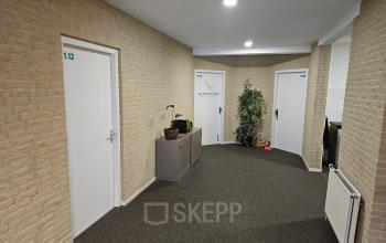 Interior view of the office space at Hambakenwetering 18, Den Bosch, featuring a simple hallway with carpeted floor, neutral-toned walls, and a few closed doors, suitable for office space rental.