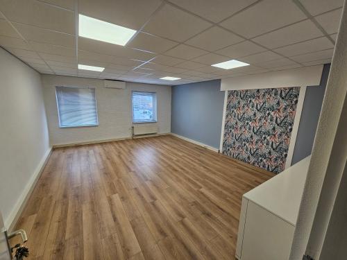 Spacious office at Hambakenwetering 18, Den Bosch with wooden flooring and decorative wall feature, ideal for office space rental.