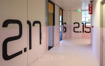 Bright corridor at Bruistensingel 500, Den Bosch, featuring modern office entrances and distinctive number designs. Perfect for those seeking office space rental in a creative environment.