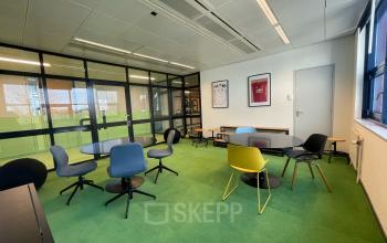 Office space at Bruistensingel 500, Den Bosch featuring a cozy workspace with colorful chairs, round tables, and large glass windows. Ideal for collaborative tasks. Perfect opportunity for office space rental.