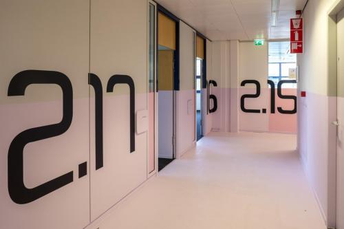 Bright corridor at Bruistensingel 500, Den Bosch, featuring modern office entrances and distinctive number designs. Perfect for those seeking office space rental in a creative environment.